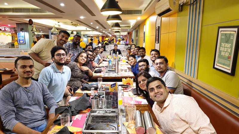 The group around a long table at a restaurant dinner